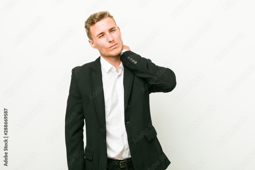 Young caucasian business man suffering neck pain due to sedentary lifestyle. Young caucasian business man suffering neck pain due to sedentary lifestyle.