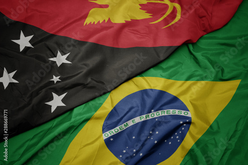 waving colorful flag of brazil and national flag of Papua New Guinea .