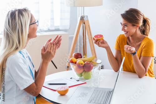 Professional nutritionist meeting a patient in the office and healthy fruits with tape measure, healthy eating and diet concept photo