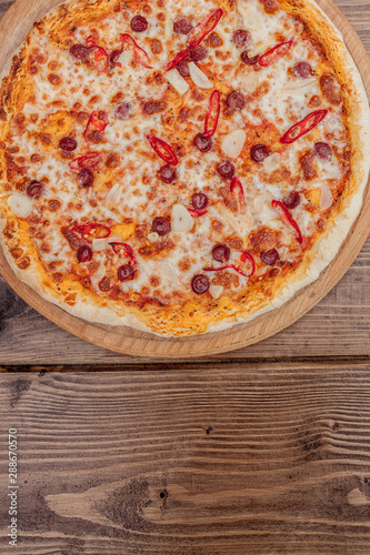 Pizza Restaurant Menu - Delicious Spicy Pizza with Sausages and Chili Pepper. Pizza on Rustic Wooden Table with Ingredients