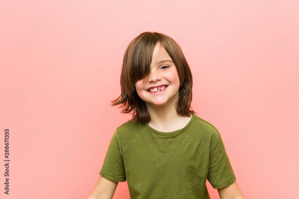 Obraz premium Little caucasian boy playing against a pink background