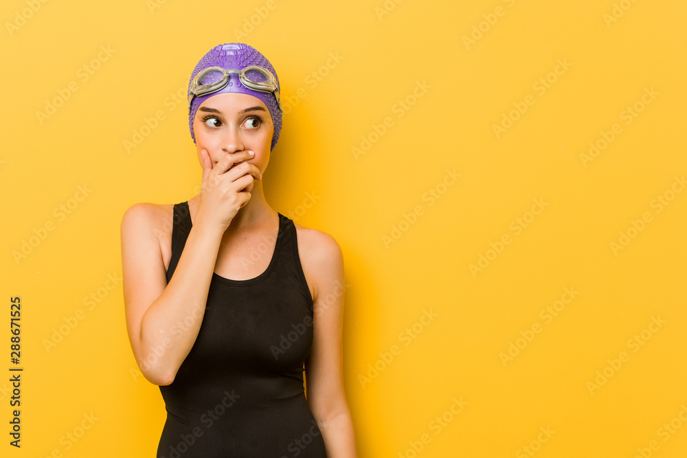 Young swimmer caucasian woman thoughtful looking to a copy space covering mouth with hand. Young swimmer caucasian woman thoughtful looking to a copy space covering mouth with hand.