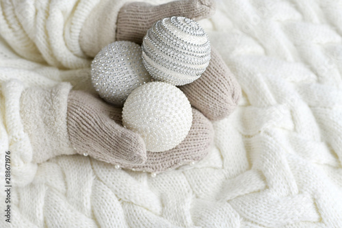 Christmas balls in the hands of mittens on a white knitted background. the concept of new year, Christmas , winter