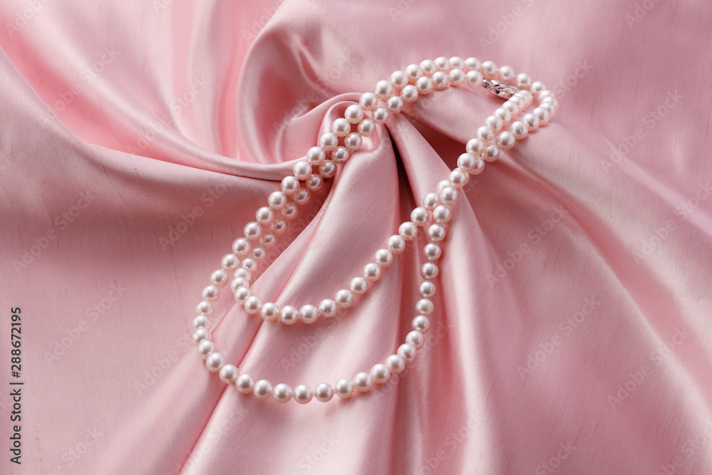 Obraz premium 布の上にのった綺麗な真珠のネックレス