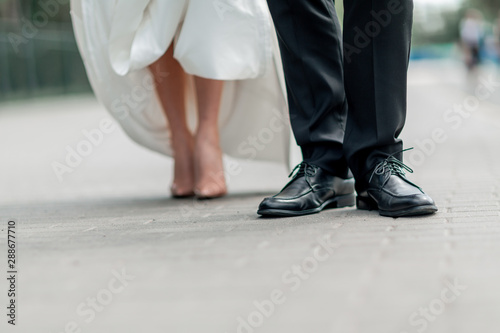 close up. the groom standing on the stone sidewalk