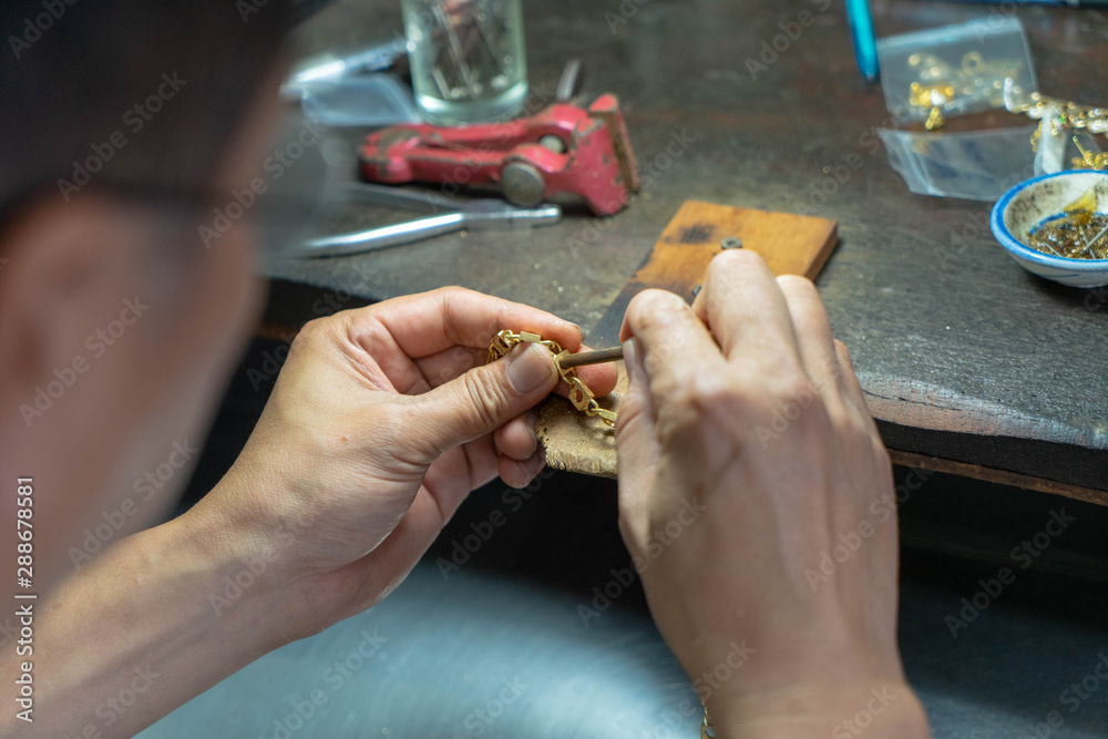 Fototapeta premium Goldsmith is making a golden ring