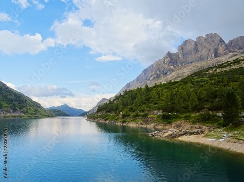 Lake Fedaia, immersed in the nature of the Dolomites of Trentino Alto Adige, near the town of Canaze, Italy - August 2019.