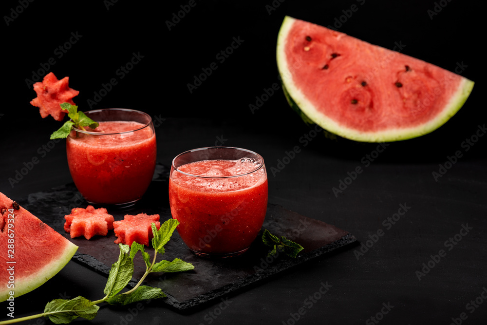 Watermelon smoothie fresh juice with mint and pieces in the shape of stars on a black background. Summer healthy drinks. Watermelon smoothie fresh juice with mint and pieces in the shape of stars on a black background. Summer healthy drinks.