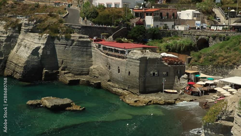 Sant'Angelo di Ischia village. Mediterranean sea near Naples. Close to Naples. The waves of the blue sea break on the cliff. Sant'Angelo di Ischia village. Mediterranean sea near Naples. Close to Naples. The waves of the blue sea break on the cliff.