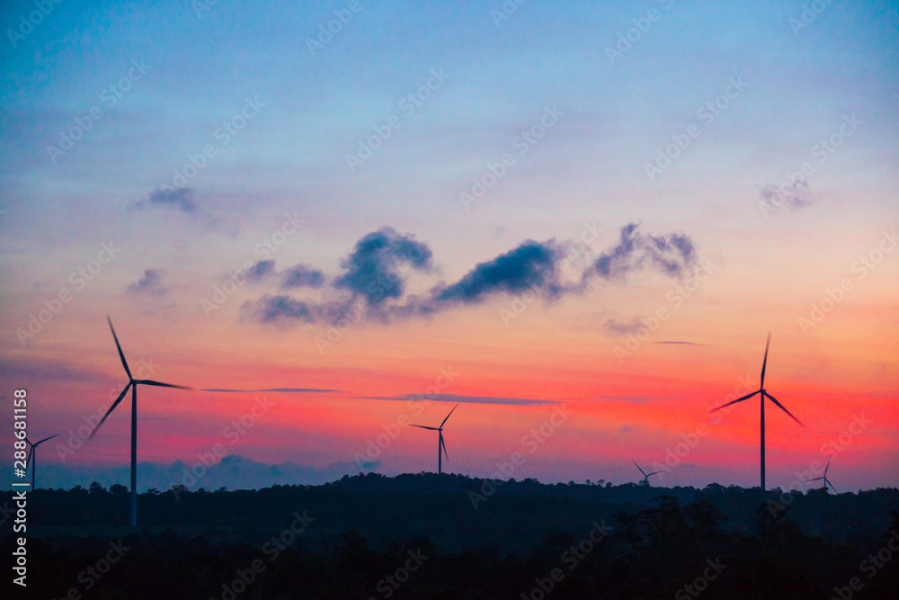 silhouette of wind turbine located on a ridge with wind blowing all the time. Making it able to effectively produce renewable electricity, which is another clean energy.