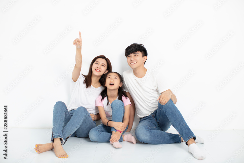happy young family sitting on floor and looking up happy young family sitting on floor and looking up