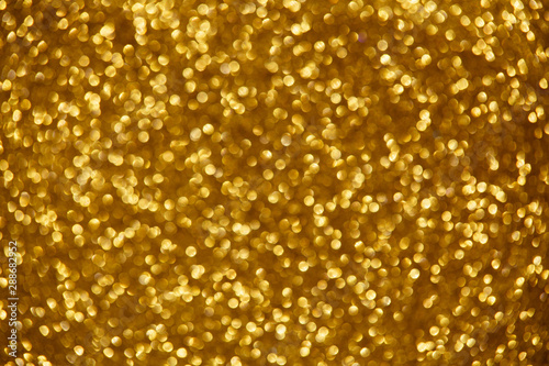 Gold glittering christmas lights. Blurred abstract background.