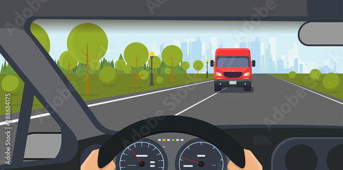 Danger on the road. Danferous incident on the highway. Inside car view. Modern car interior with steering wheel and hands. Big truck on lane. Highway to big city and solid lane on the road.