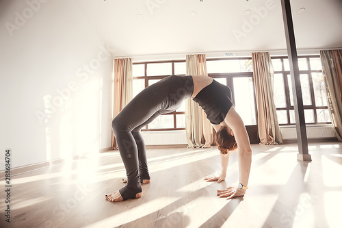yoga girl stands on hands / concept of yoga health, professional stretching coach, handstand, headstand balance in yoga