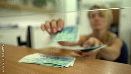 Bank. Cashier. Employee. The client, customer in a bank invests, pays, gives US dollar, shekel IS bills, money the cashier. 1