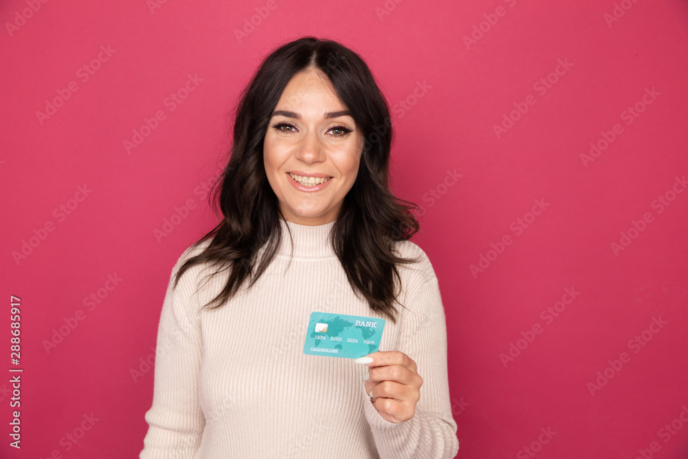 Happy woman with credit card isolated in the pink studio Happy woman with credit card isolated in the pink studio