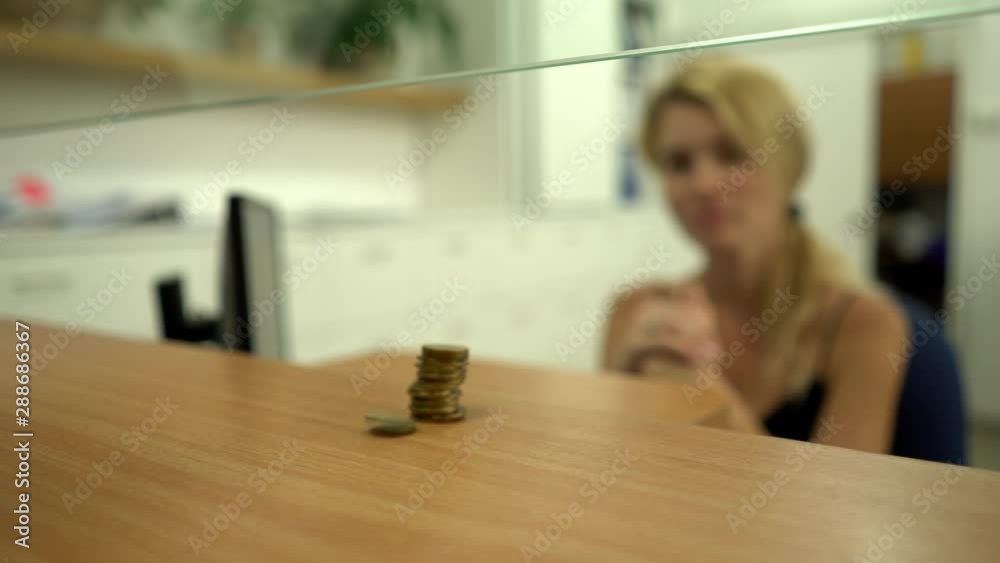 The client, customer in a bank invests, pays, gives coins the cashier Folds in a column. The client, customer in a bank invests, pays, gives coins the cashier Folds in a column.