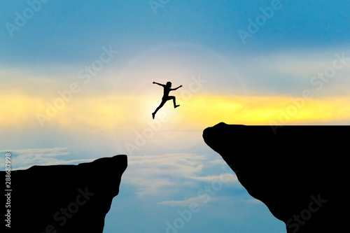 Papier peint Man jump through the gap between hill.man jumping over cliff