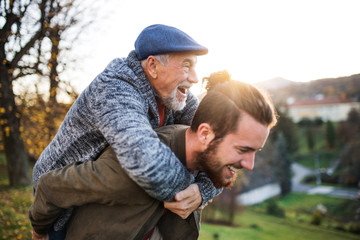 Senior father and his son walking in nature, having fun.