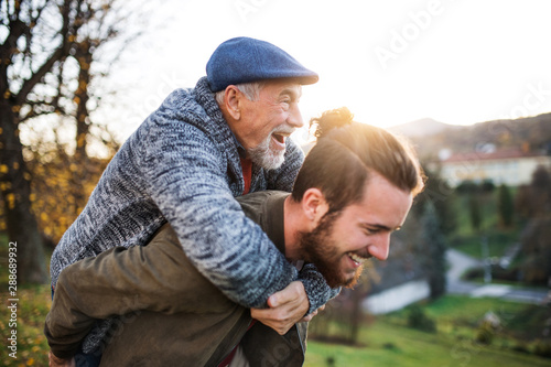 Senior father and his son walking in nature, having fun.