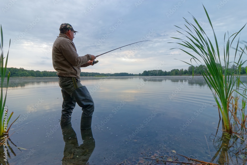 Angler catching the fish during cloudy day. Angler catching the fish during cloudy day.