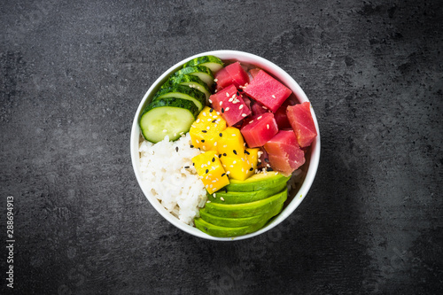 Tuna poke bowl on black background top view. photo