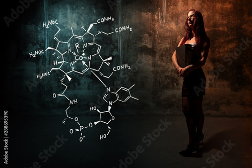 Sexy girl or secretary or female student presenting handdrawn chemical formula of Vitamin B12