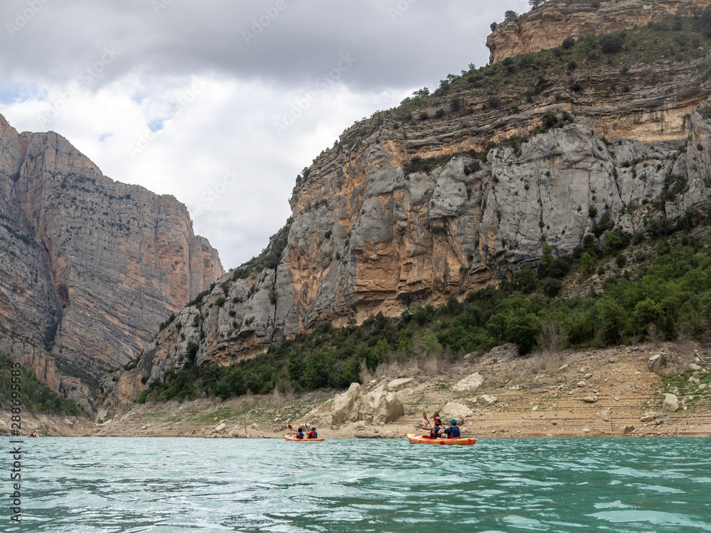Group of tourists in kayaks explore Congost de Mont-rebei (Mont-rebei gorge) at Noguera Ribagorcana river, Spain