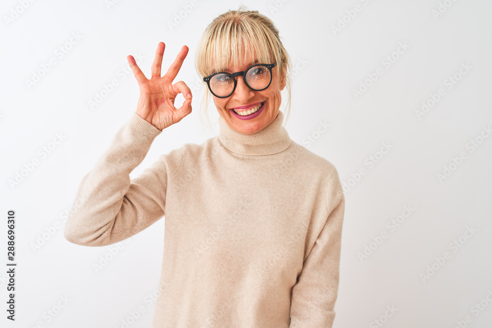 Middle age woman wearing turtleneck sweater and glasses over isolated white background smiling positive doing ok sign with hand and fingers. Successful expression. Middle age woman wearing turtleneck sweater and glasses over isolated white background smiling positive doing ok sign with hand and fingers. Successful expression.