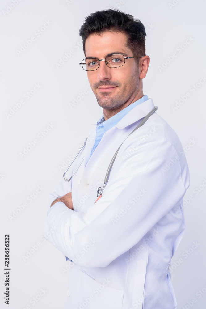 Profile view of young handsome man doctor with eyeglasses looking at camera Profile view of young handsome man doctor with eyeglasses looking at camera