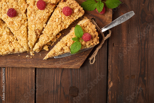 Foto sliced triangular pieces of crumble pie with apples on a brown wooden board