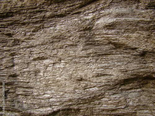 Golden stone for background. Shiny yellow layers. Texture, cracks.