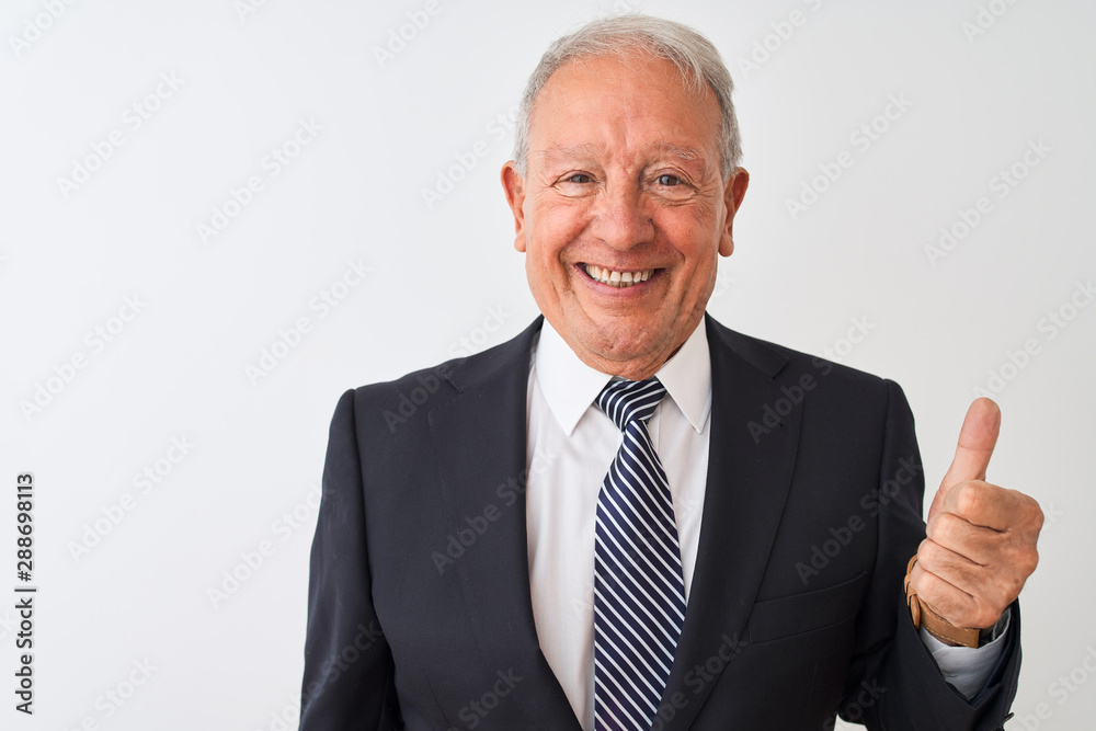 Senior grey-haired businessman wearing suit standing over isolated white background doing happy thumbs up gesture with hand. Approving expression looking at the camera showing success. Senior grey-haired businessman wearing suit standing over isolated white background doing happy thumbs up gesture with hand. Approving expression looking at the camera showing success.
