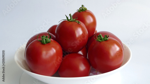 Red tomatoes on a white plate. Healthy food. 