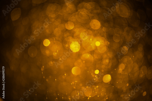 Abstract blurred background of golden water droplets bokeh with light effect