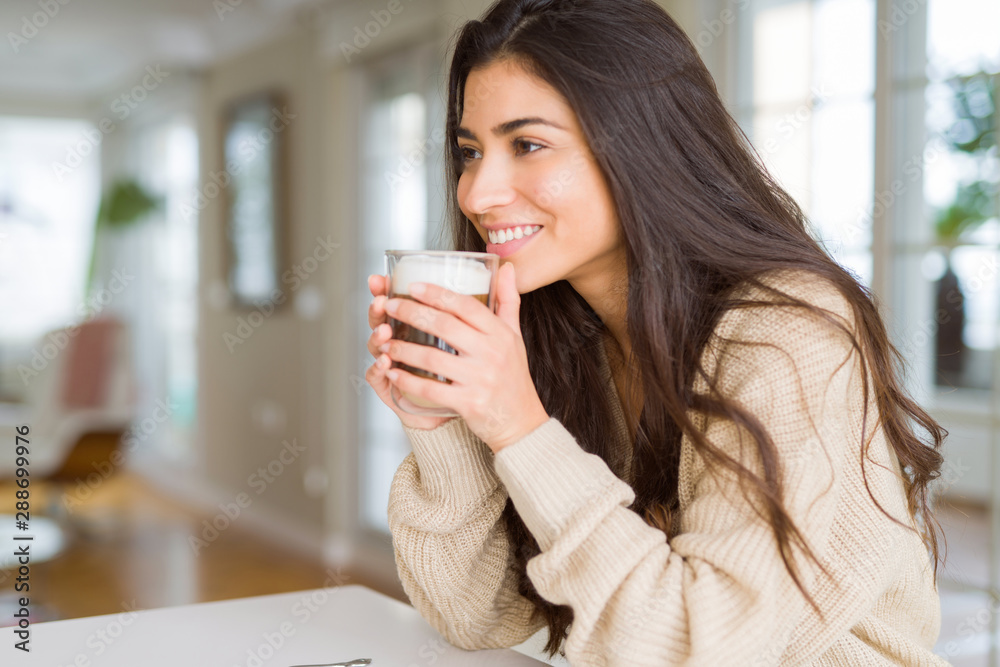 Beautiful young girl drinking a cup of coffee at home and smiling Beautiful young girl drinking a cup of coffee at home and smiling