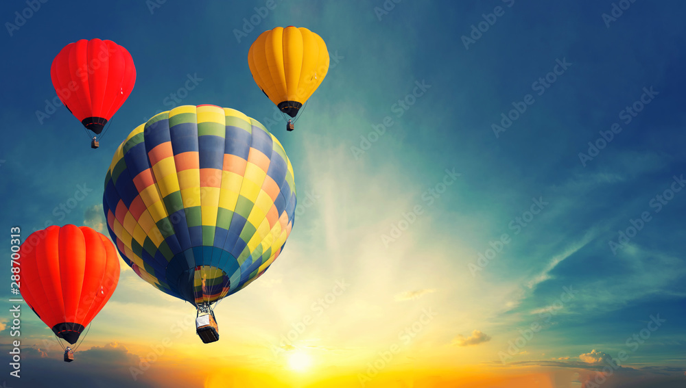 Fototapeta premium Colorful balloons floating in the sky at sunset.