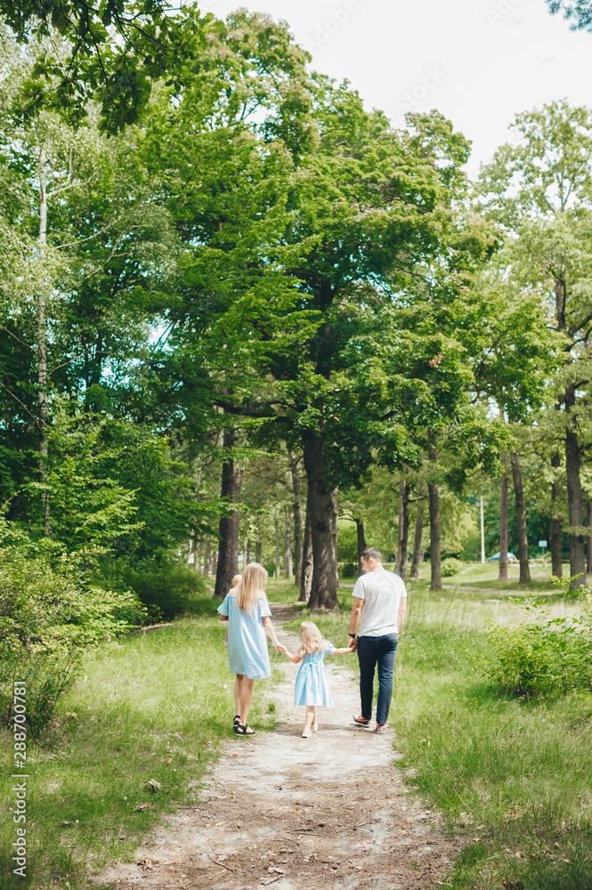 Rear view of young family walking in forest