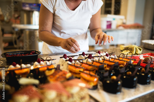 Young woman decorating raspberry cookies stock photo