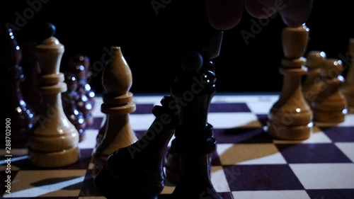 Chess pieces sway and fall on a chessboard in slow motion photo