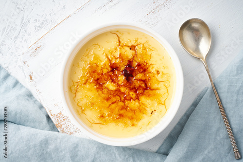 Crema catalana, Spanish dessert in white ramekin with spoon, top view