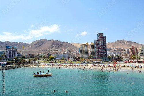 Crowded beach in Antofagasta, Chile, wide angle shot taken from the sea. photo