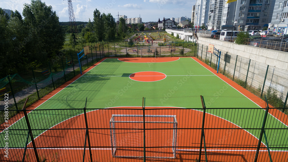 Fototapeta premium Soccer field among tall houses.