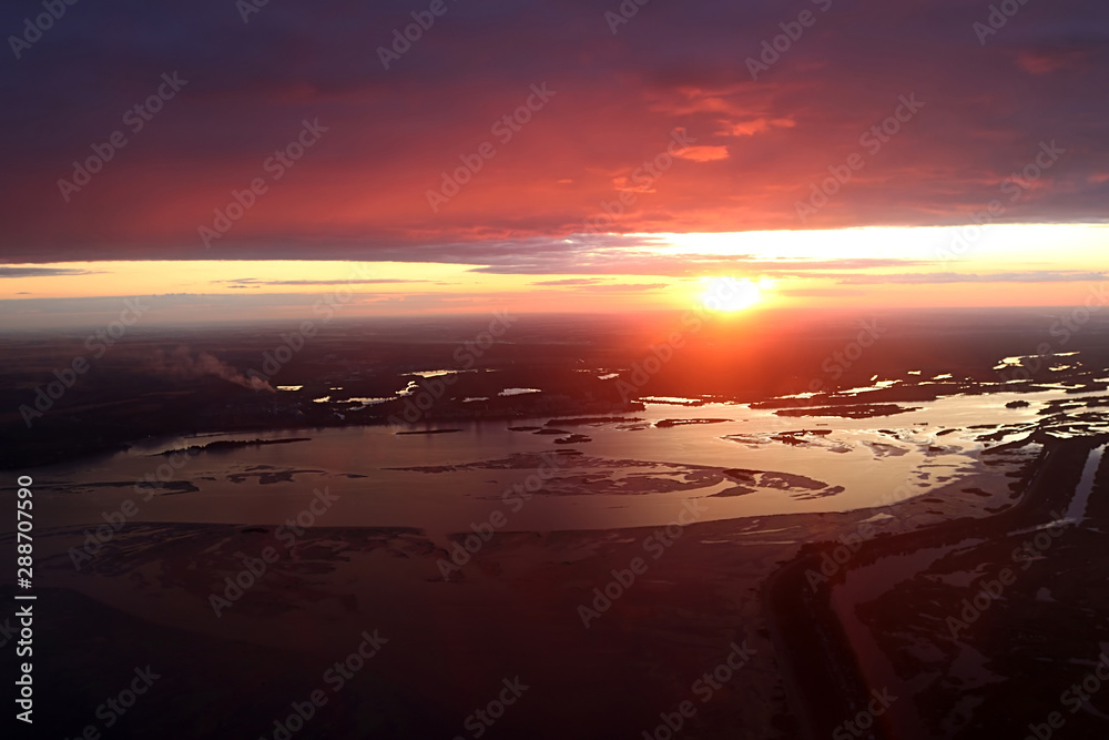 Colorful dramatic sky with cloud at sunset over Dnipro river near Kyiv, Ukraine. View from plane. Sunset rays of the sun Colorful dramatic sky with cloud at sunset over Dnipro river near Kyiv, Ukraine. View from plane. Sunset rays of the sun