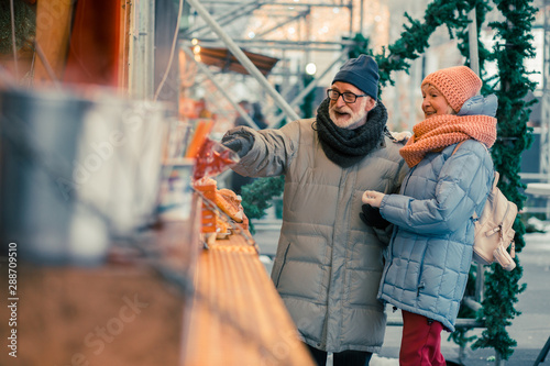Positive pensioners choosing street food at the fair