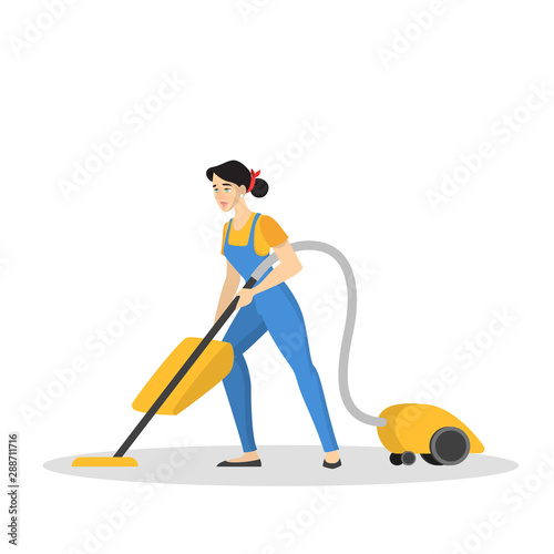 Woman in the uniform cleaning floor using vacuum cleaner