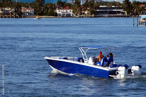 Blue motorboat with white trim powered by two outboard engines