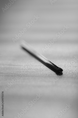 one used match on the table, black and white photo