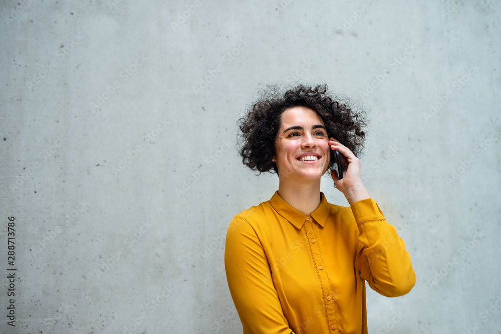 Young student or businesswoman with smartphone in a library or office.