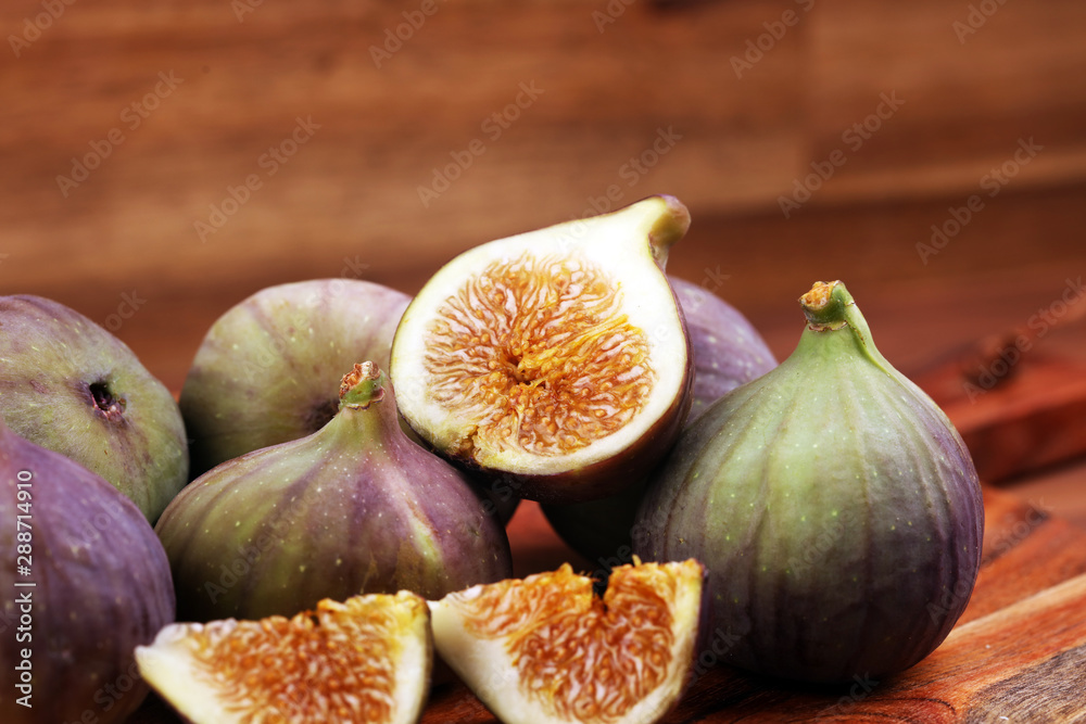 Obraz premium Fresh figs. Food Photo. whole and sliced figs on rustic background.